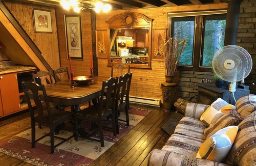 Cap-Pele Ski Chalet | Luxurious secluded rustic wooden chalet on edge of tranquil pond next to beach.