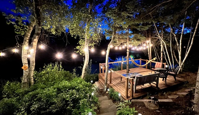 Luxurious secluded rustic wooden chalet on edge of tranquil pond next to beach.