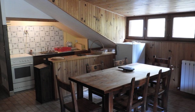 Mountain gîte under the roof facing the forest